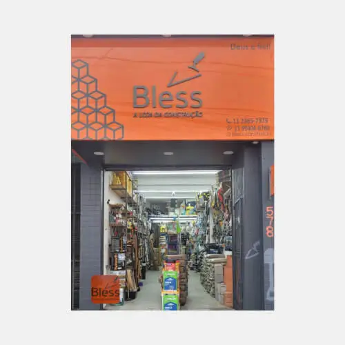 Fachada da loja Bless A Loja da Construção, com o interior da loja visível, mostrando produtos e materiais de construção.