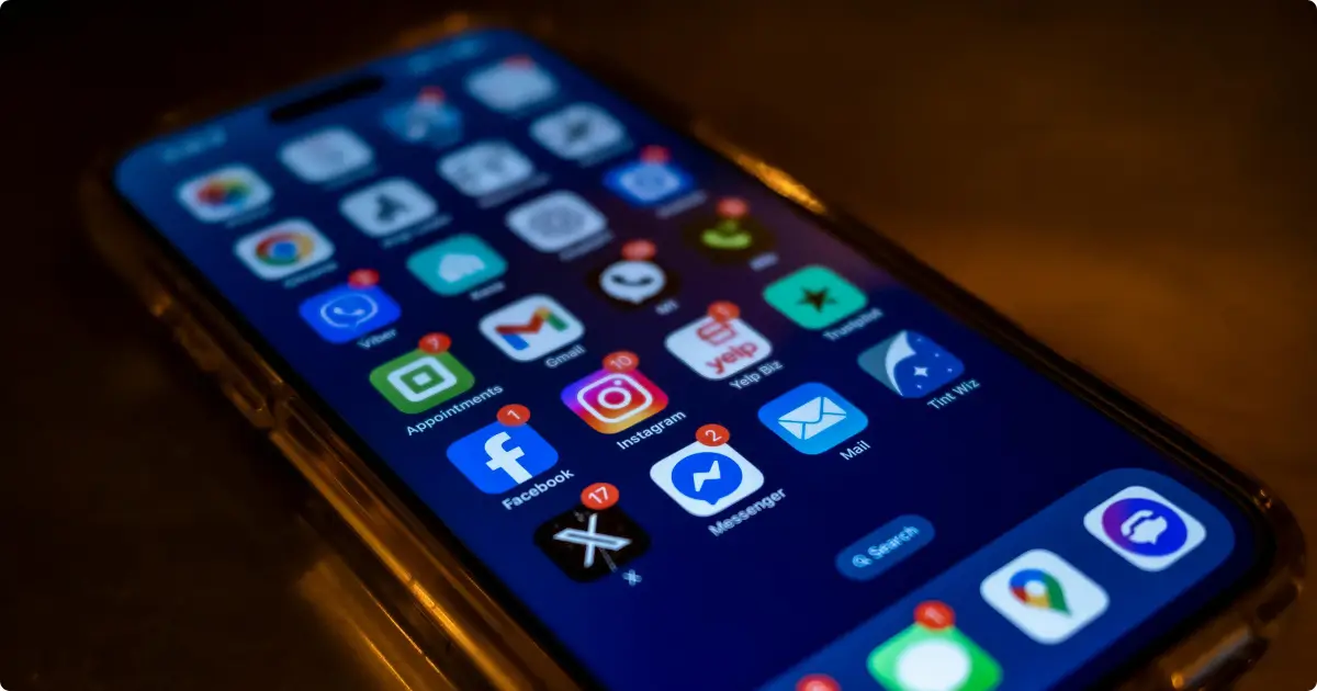 Close-up de um smartphone Motorola moderno com tela escura cheia de ícones de aplicativos, representando o review dos melhores celulares Motorola custo-benefício.